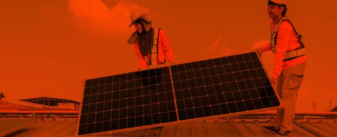 men installing solar panels on roof